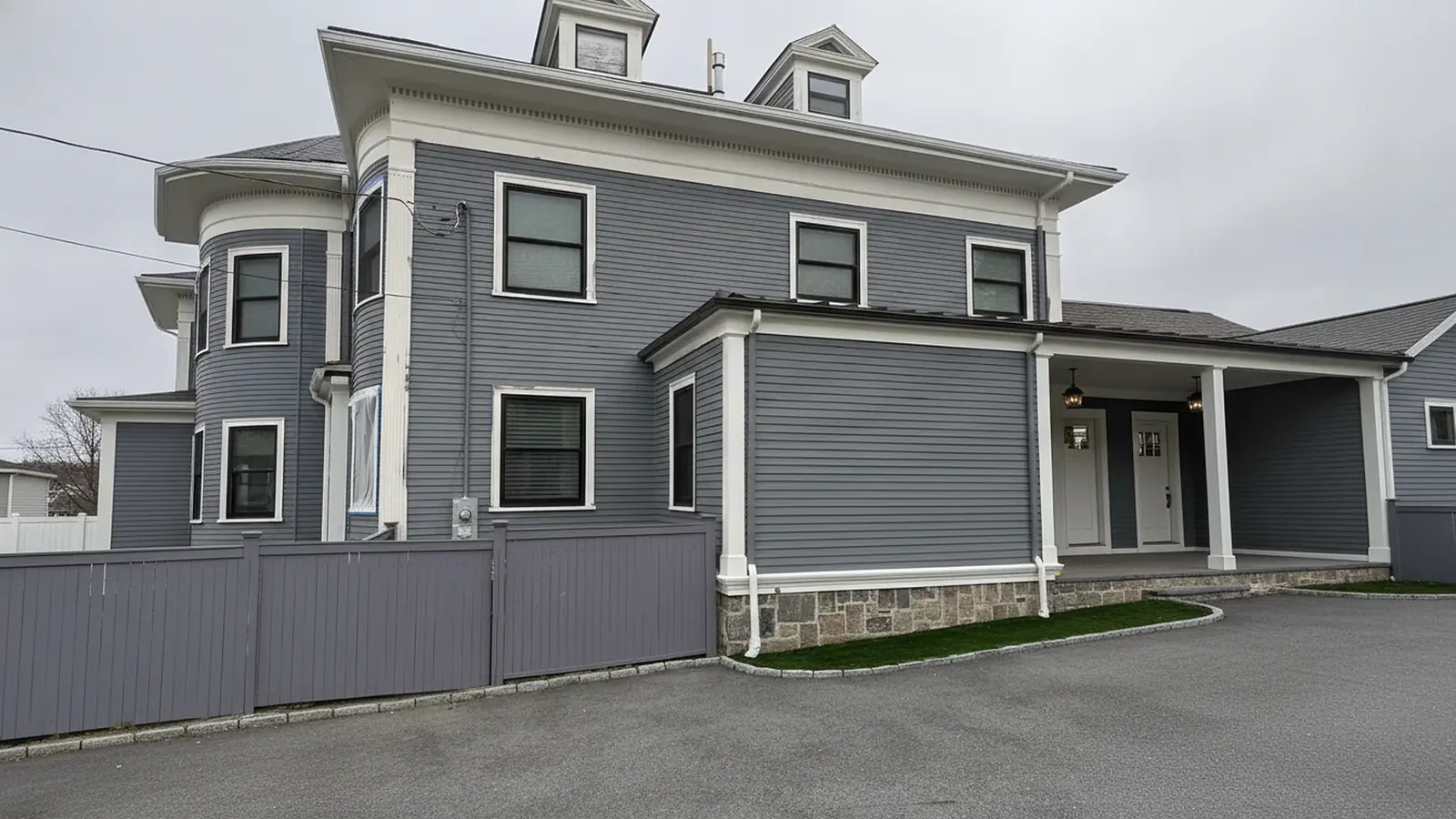 Gray colonial house with crisp white trim after exterior painting, Winthrop, MA