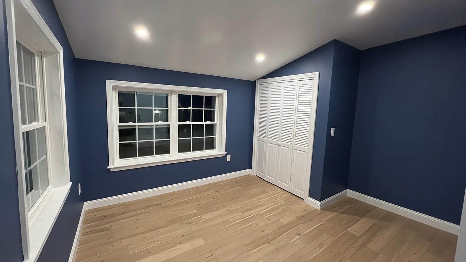 Bedroom painted navy blue with white trim