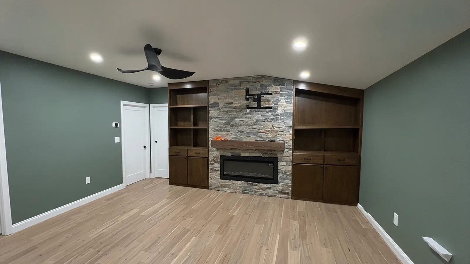 Sage green living room with stone fireplace and freshly painted walls