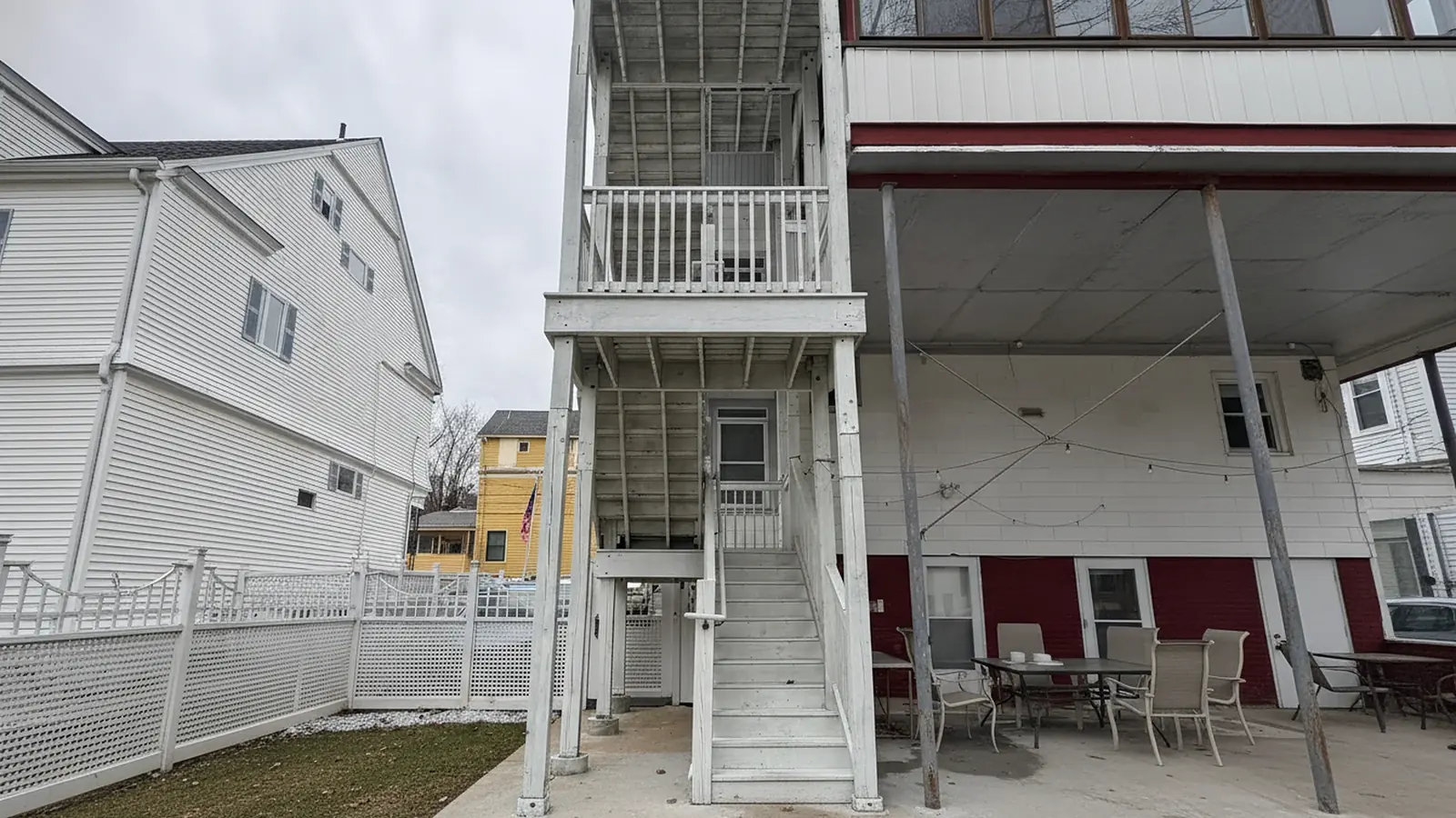 Three-story multi-unit porch painted gray and white